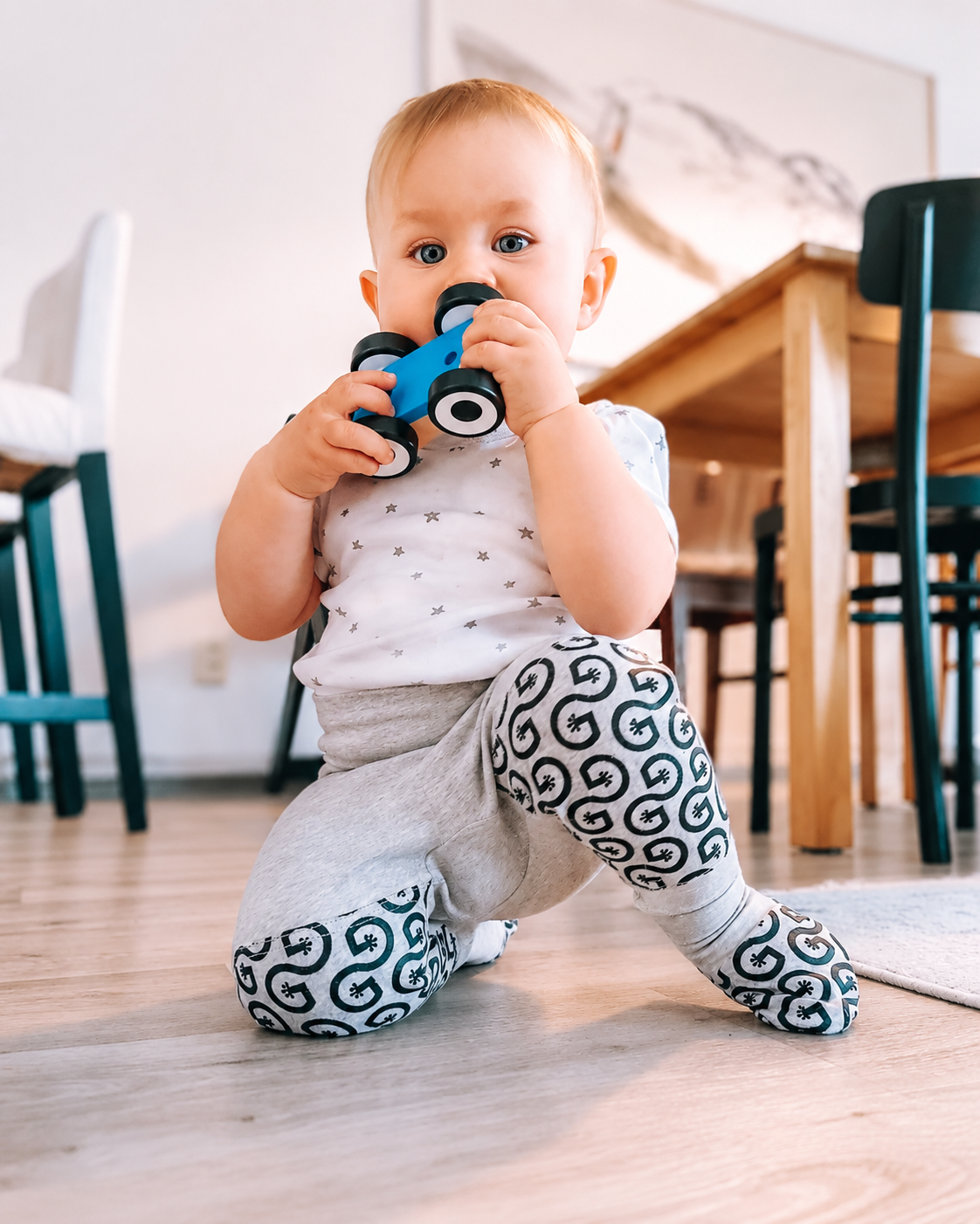 Baby wearing Geckoeco grip clothing on a smooth floor